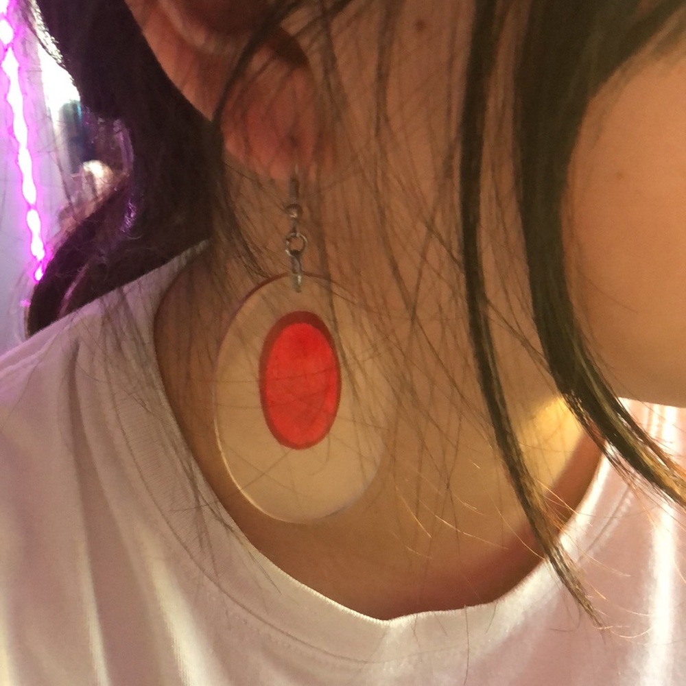 Clear light weight acrylic earrings with red foil imbedded in circles.